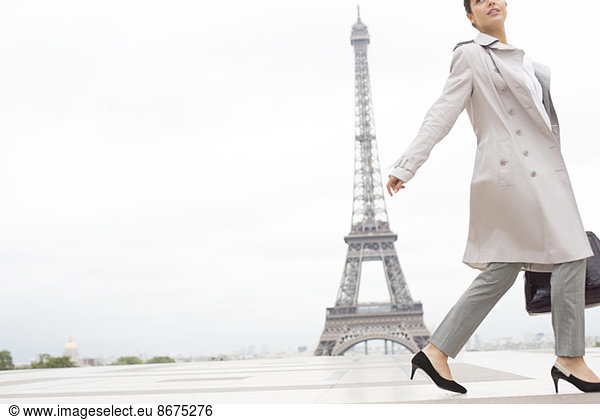 Businesswoman walking past Eiffel Tower  Paris  France