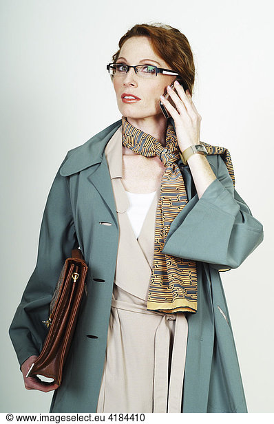 Businesswoman wearing glasses making a call with a mobile phone (cellphone)