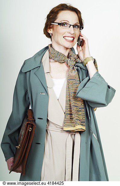 Businesswoman wearing glasses making a call with a mobile phone (cellphone)