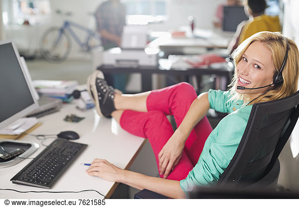 Businesswoman wearing headset at desk