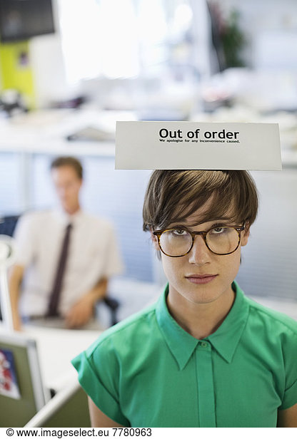 Businesswoman wearing ‘out of order’ sign