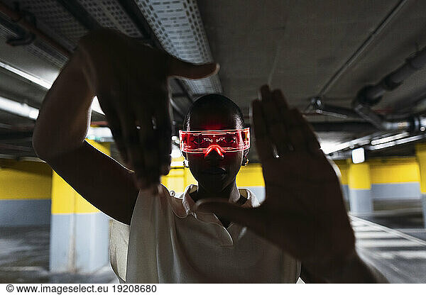Businesswoman wearing smart glasses and looking through finger frame