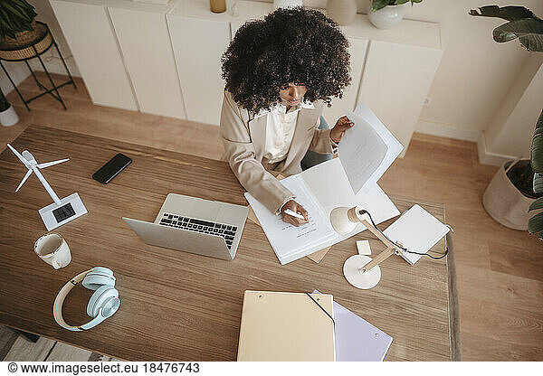 Businesswoman with Afro hairstyle taking notes in office