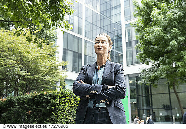 Businesswoman with arms crossed standing at office park