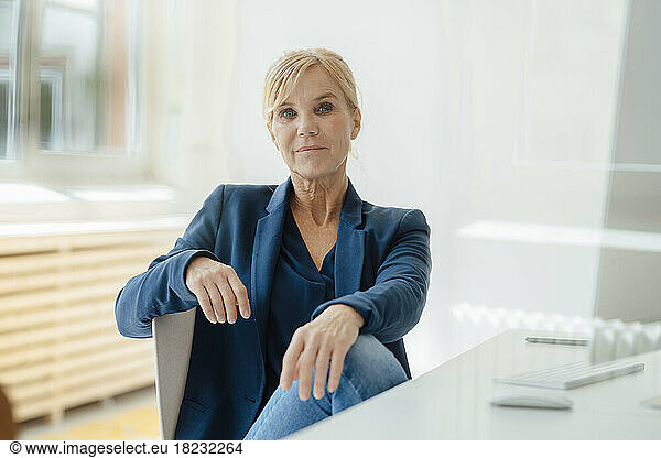 Businesswoman with blond hand by desk