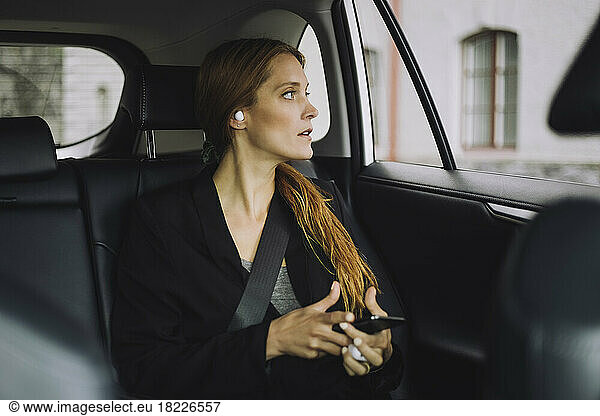Businesswoman with brown hair sitting in car