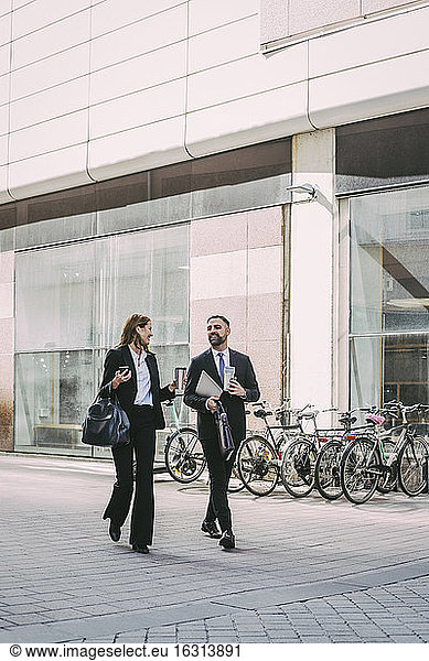 Businesswoman with coworker walking in city