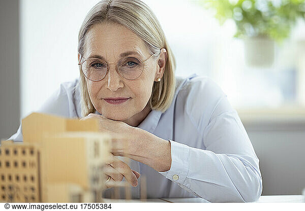 Businesswoman with eyeglasses looking at model in office