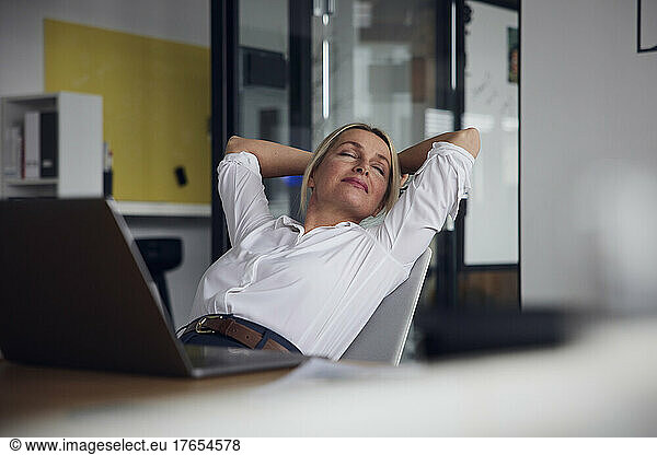 Businesswoman with eyes closed relaxing on chair