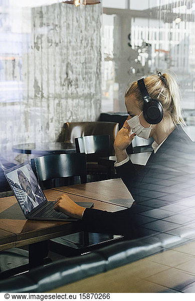 Businesswoman with face mask having video call