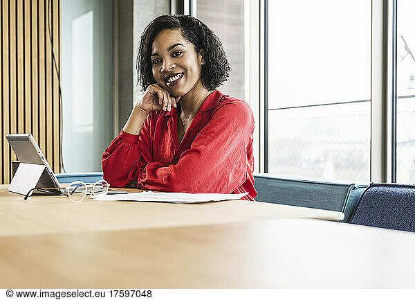 Businesswoman with hand on chin at desk in office