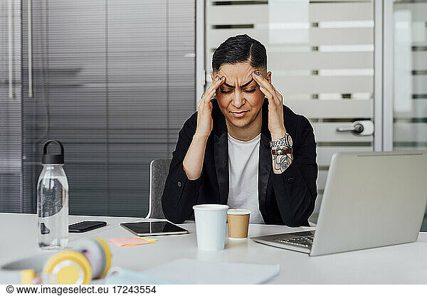 Businesswoman with head in hands at office