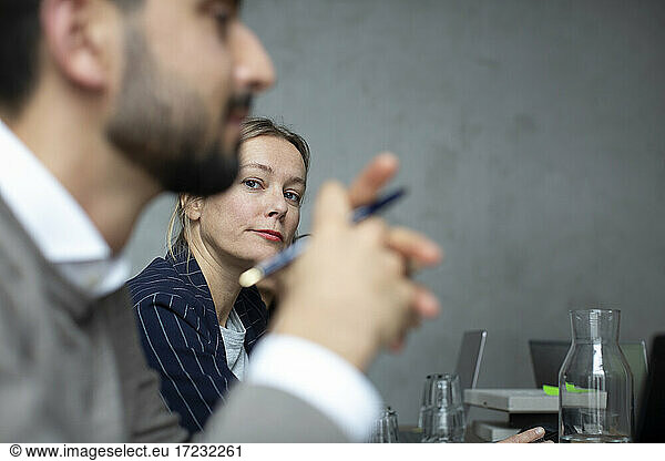 Businesswoman with male colleague in discussion during meeting at creative office
