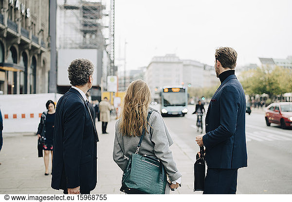 Businesswoman with male coworkers standing in city