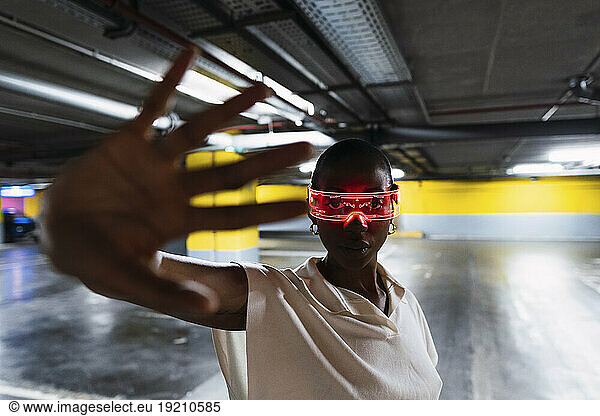 Businesswoman with smart glasses gesturing in parking garage