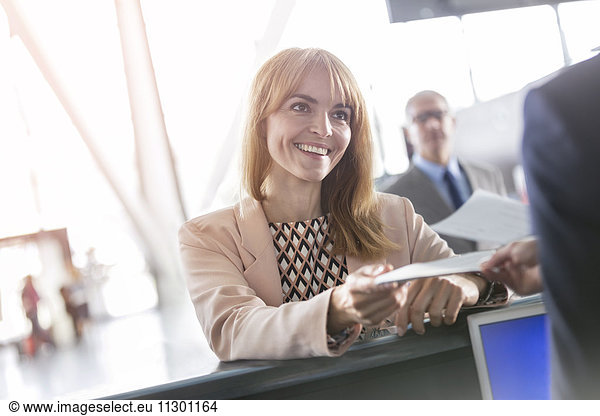 Businesswoman with ticket at airport check-in counter