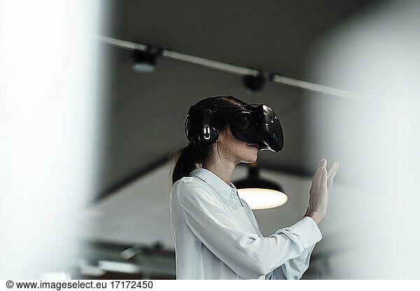 Businesswoman with virtual reality simulator at office
