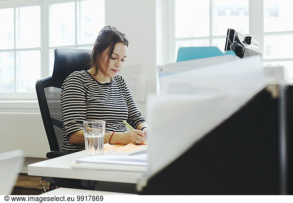 Businesswoman working at desk in creative office