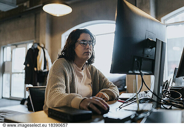 Businesswoman working on computer at desk in startup company
