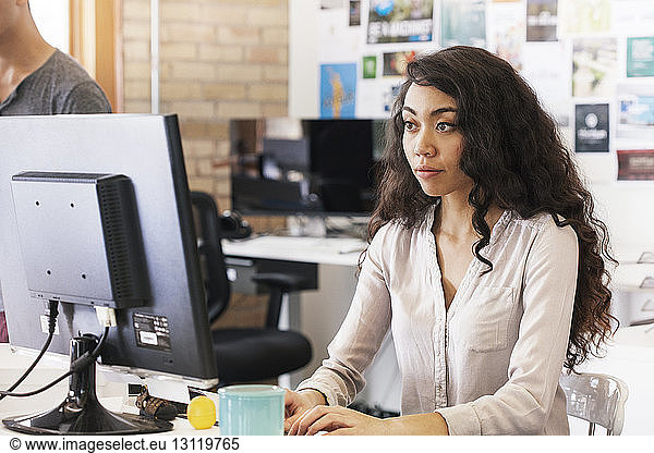 Businesswoman working on desktop computer in office
