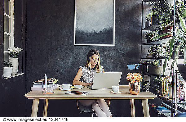 Businesswoman working on laptop computer at home office