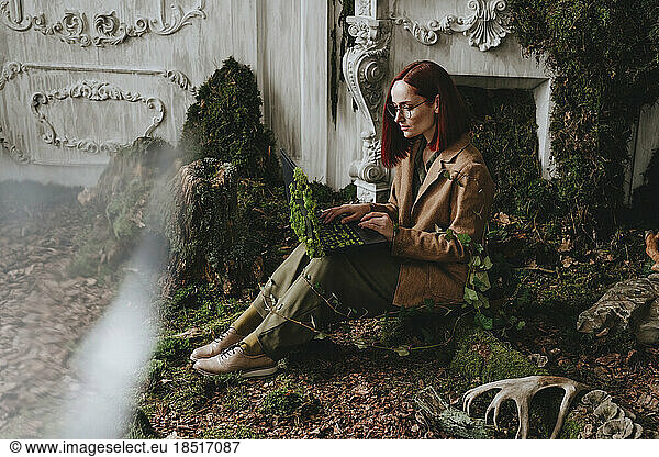 Businesswoman working on laptop sitting in abandoned place