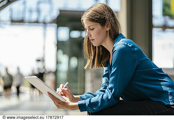 Businesswoman working on tablet PC with digitized pen