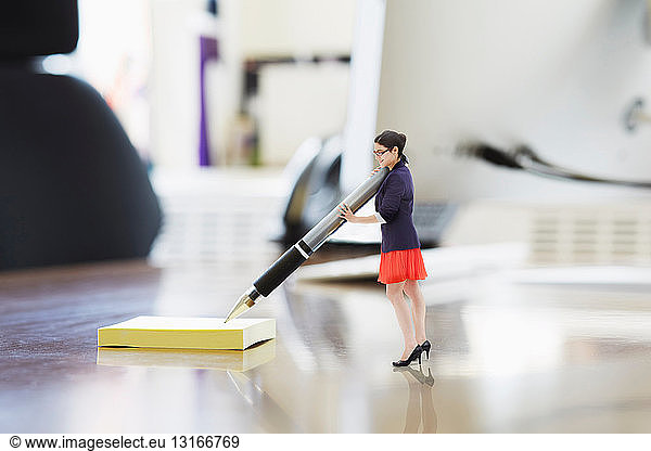 Businesswoman writing on large adhesive label on oversized desk