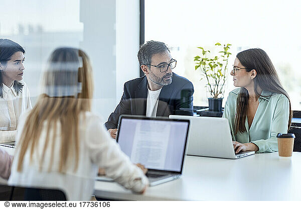 Businesswomen and businessman discussing in board room at office