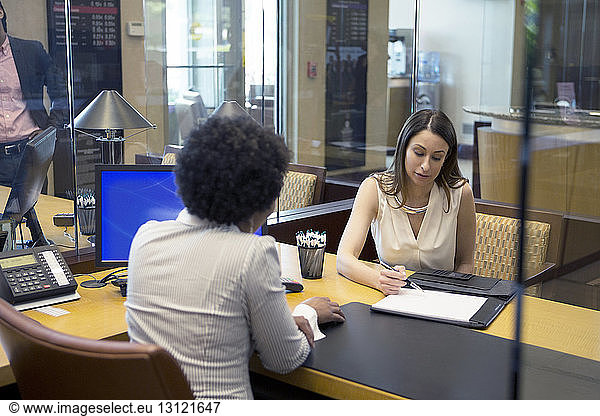 Businesswomen discussing about document at desk in office