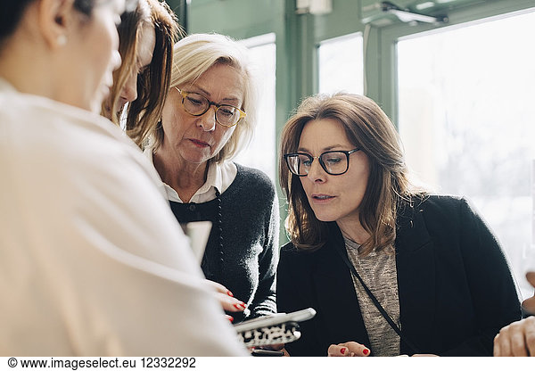 Businesswomen looking at file in meeting