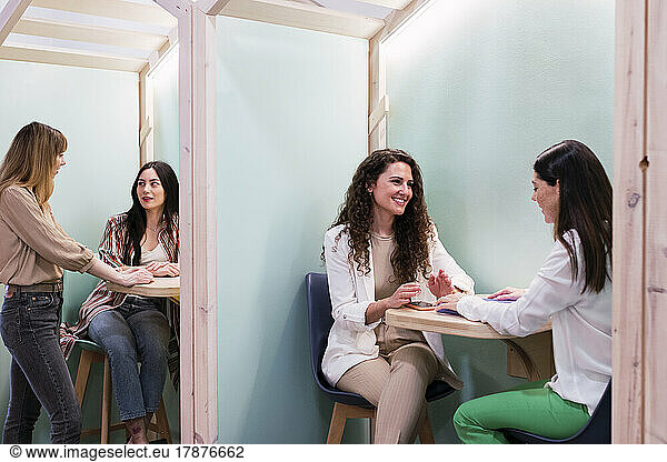Businesswomen talking in office cubicles