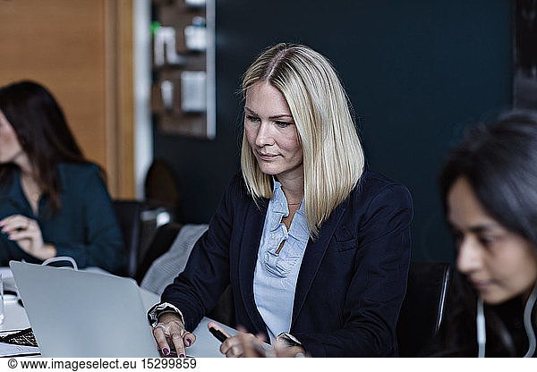 Businesswomen working at conference table in board room at office