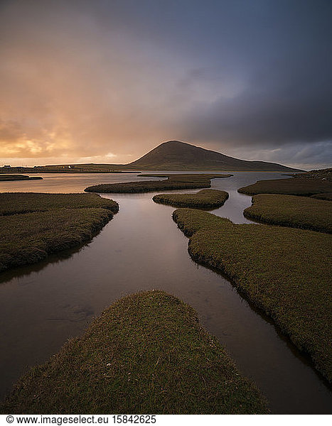 Bust of light over Ceapabhal and coastal marsh  Northton - An Taobh Tuath  Isle of Harris  Scotland