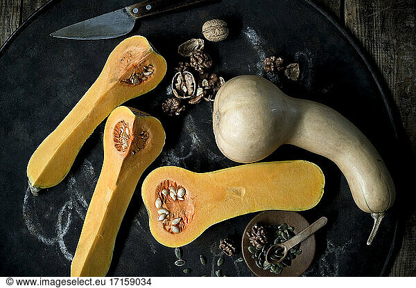 Butternut pumpkins (Cucurbita moschata)  pumpkin seeds and walnuts against rustic background