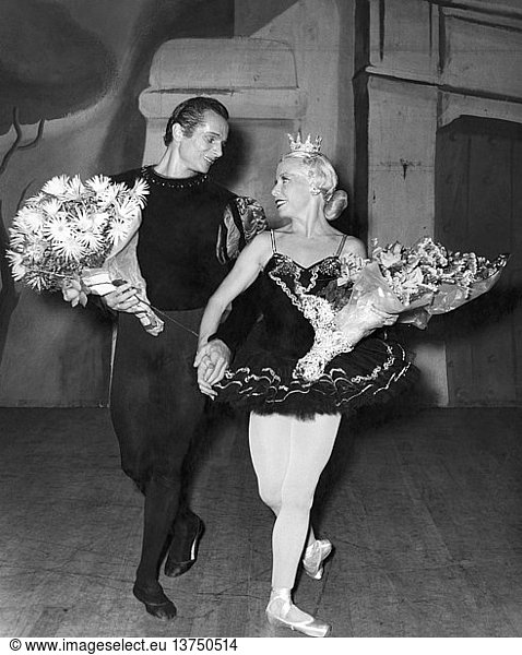 c. 1970 A ballet couple take their bows with bouquets in their arms.