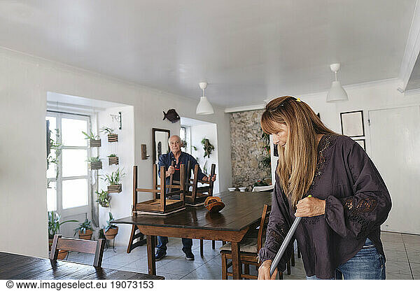 Cafe owner with colleague cleaning in coffee shop