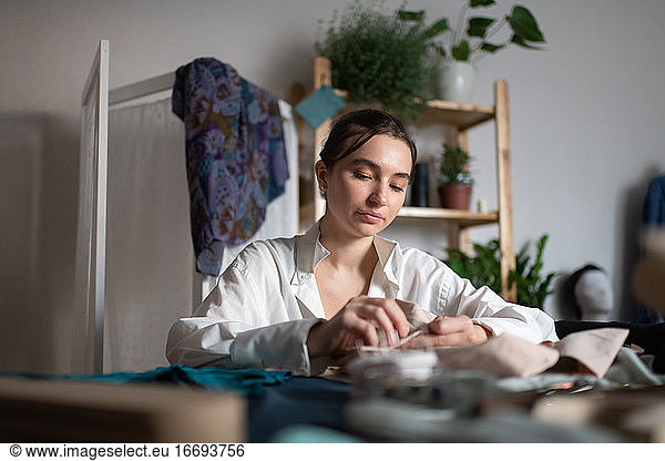 Calm home business owner sewing clothes