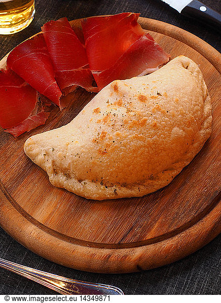 Calzone pizza with mozzarella cheese and speck smoked ham  Italy
