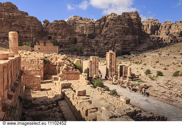 Camel train approaches Temenos Gateway with Qasr al-Bint temple  City of Petra ruins  Petra  UNESCO World Heritage Site  Jordan  Middle East