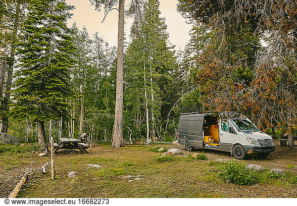 Camper van parked on campsite in northern California forest.