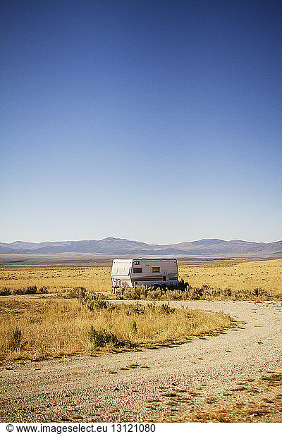 Camper van parked on field against clear sky