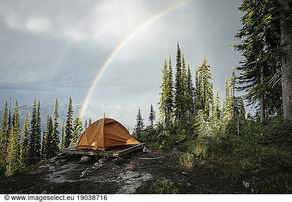 Camping tent in mountain forest with rainbow  British Columbia  Canada
