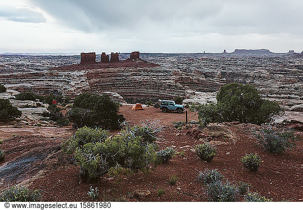 campsite with a jeep and orange tent in the maze canyonlands utah