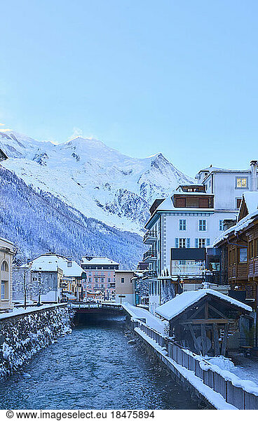 Canal amidst buildings in front of mountains