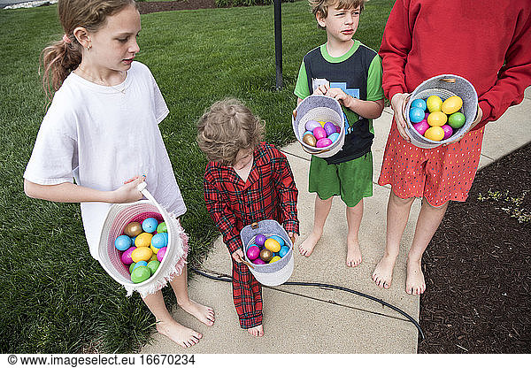 Candid Image of Four Siblings In Pajamas Outside Holding Easter Basket