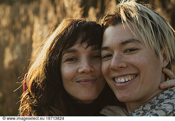 candid portrait of queer couple in golden sun on autumn hike