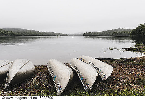 Canoes Line the Shore of Indian Lake on a Foggy Morning