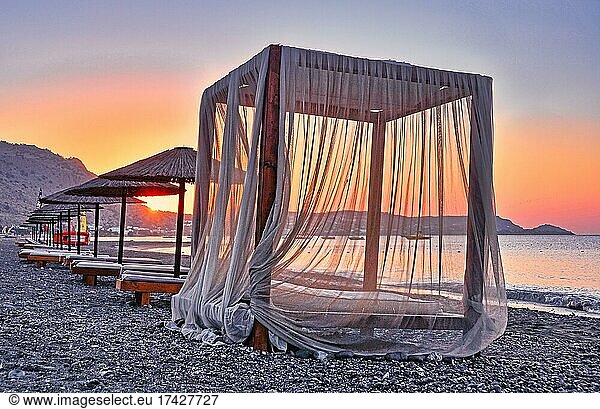 Canopy for beach loungers with curtains  sunrise  beach  Rhodes  Greece  Europe