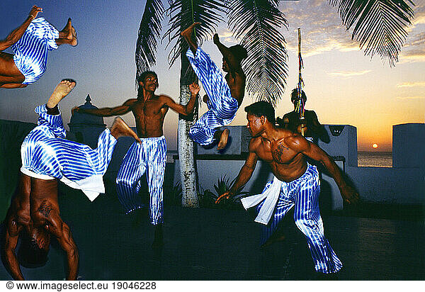 Capoeira fighters at sunset